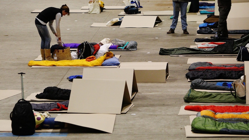 CEOs lay cardboard under their sleeping bags at the Vinnies CEO Sleepout in Sydney.