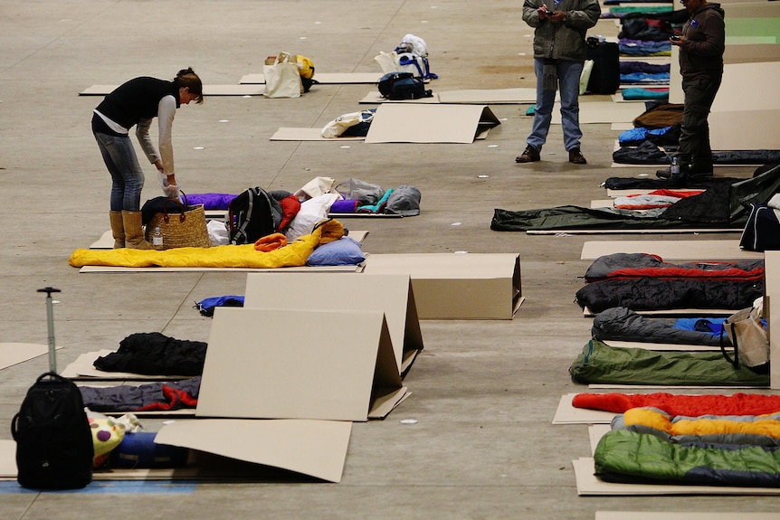 CEOs lay cardboard under their sleeping bags at the Vinnies CEO Sleepout in Sydney.