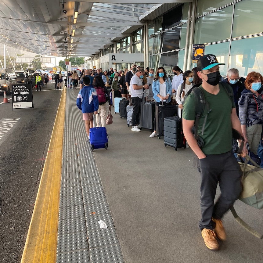 People in a row outside building 