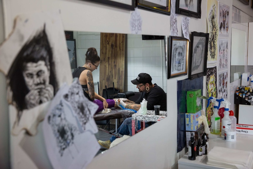 Ararat tattoo artist Aaron Thomas works on a client.
