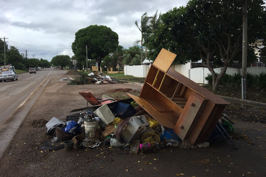 Ruined belongings sit in piles on the footpath outside Townsville homes.
