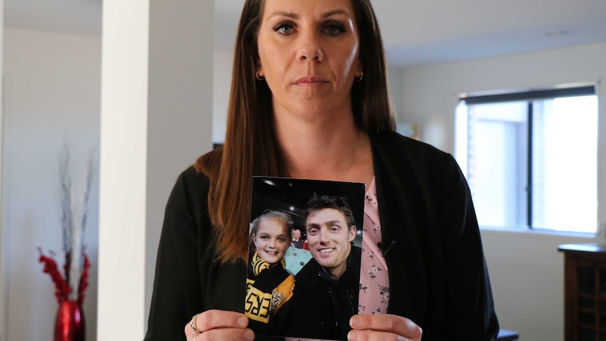 Amanda Dunn holds a photo of her late husband Roger