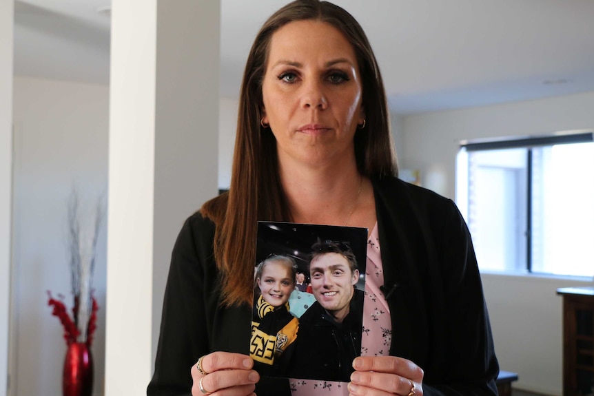 Amanda Dunn holds a photo of her late husband Roger