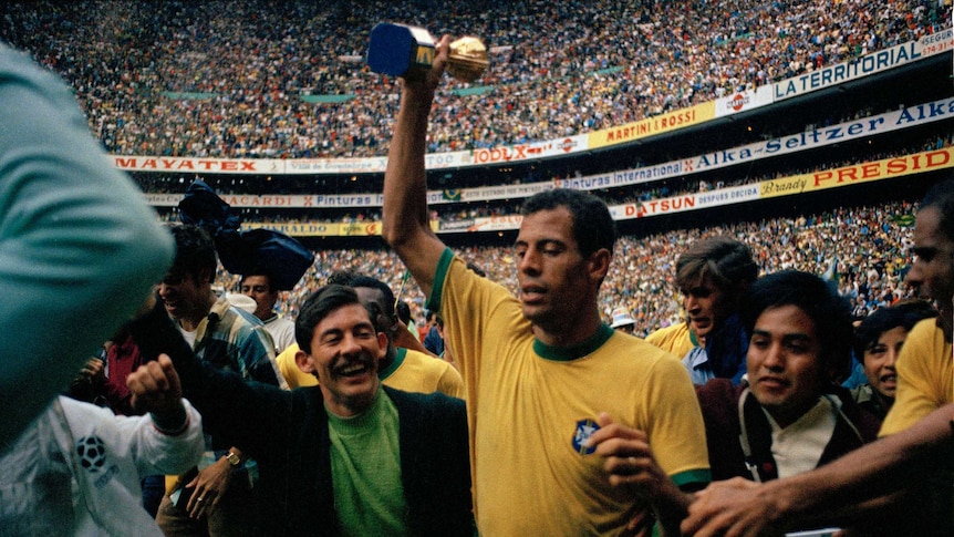 Brazil soccer captain Carlos Alberto (C) holds Jules Rimet Trophy after 1970 World Cup final.