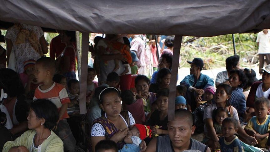 Tsunami victims gather underneath a temporary shelter