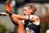 A cropped version of the image of Tayla Harris kicking a football.