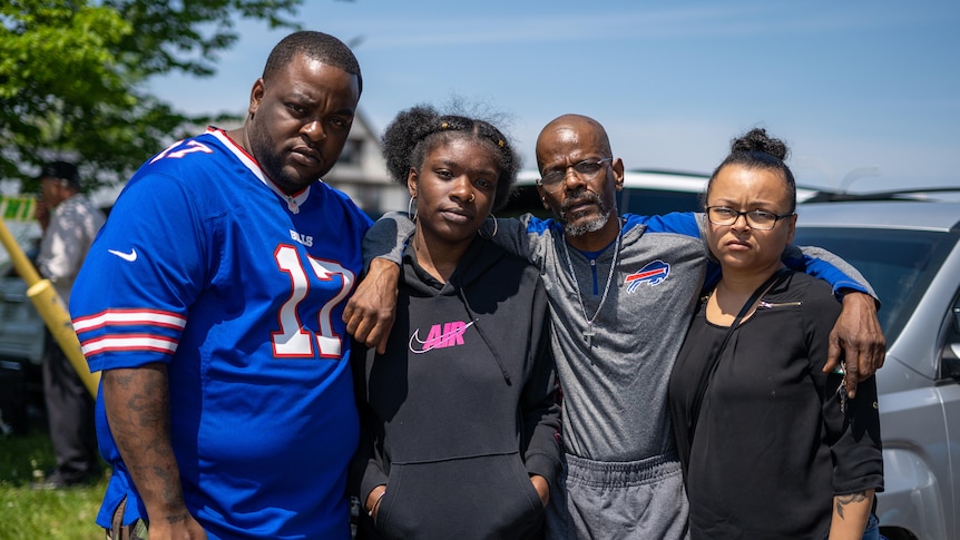 Deja Brown stands with three other family members looking at the camera with arms around each other. 