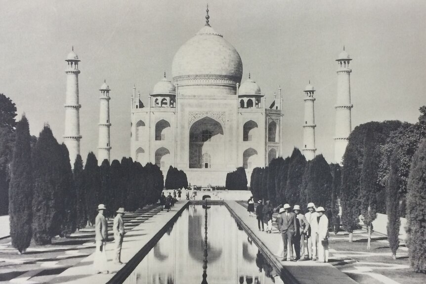 Schwarzweißfoto des Taj Mahal in den 1920er Jahren.  Die Schüler befinden sich auf beiden Seiten eines Teichs davor.