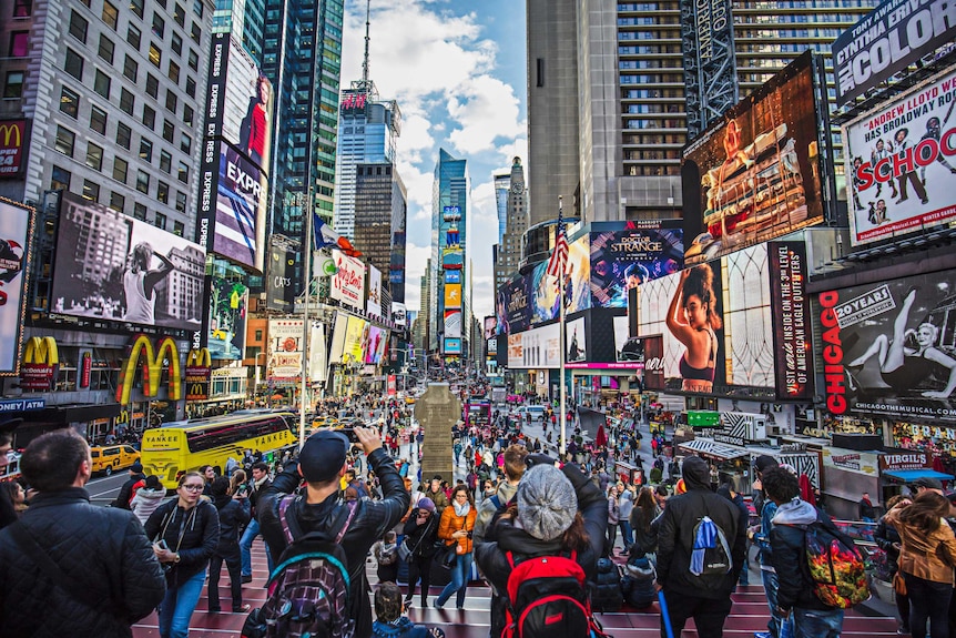 Times Square in New York full of people, billboard advertisements, and lights