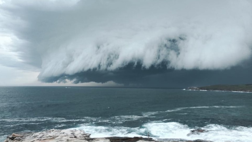 A storm cloud rolls over the ocean