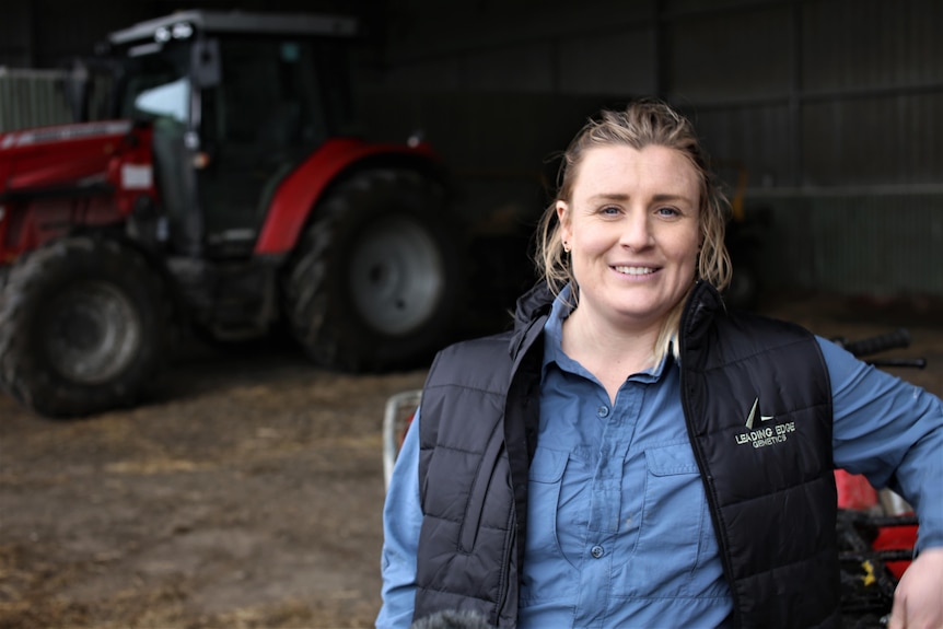 Photo of a woman standing in front of a tractor.