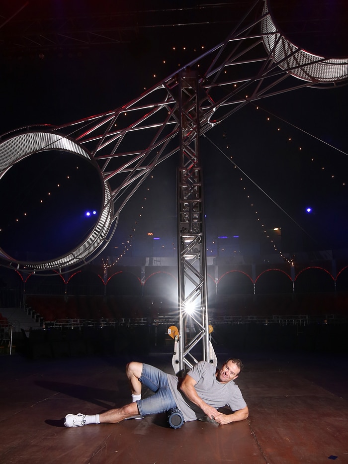 Joseph Ashton uses a foam roller to stretch before performing in Infamous.