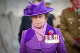 Princess Anne in a vibrant purple jacket with matching scarf and hat 