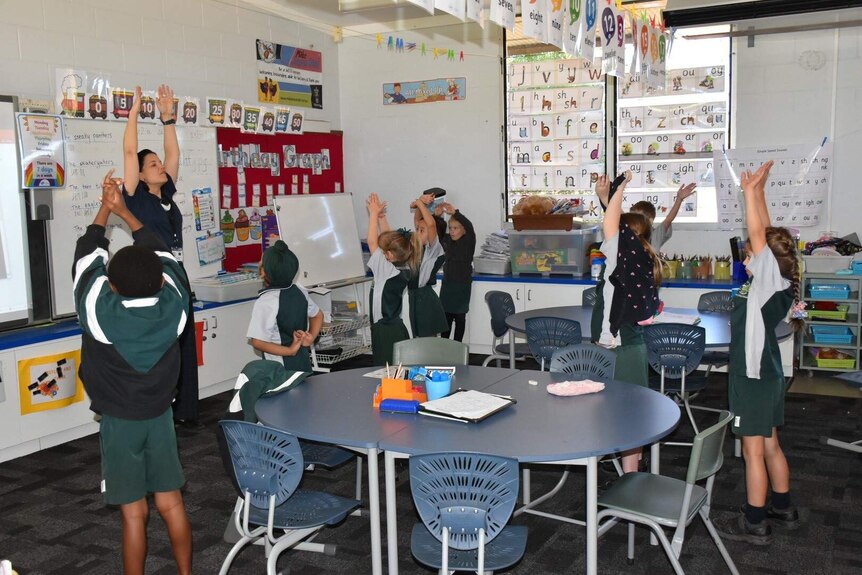 Children participate in an exercise from an app in a classroom.