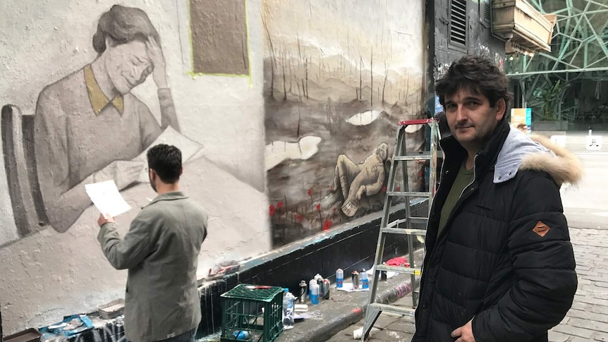 Artist Adrian Doyle in Hosier Lane in Melbourne in front of his mural.