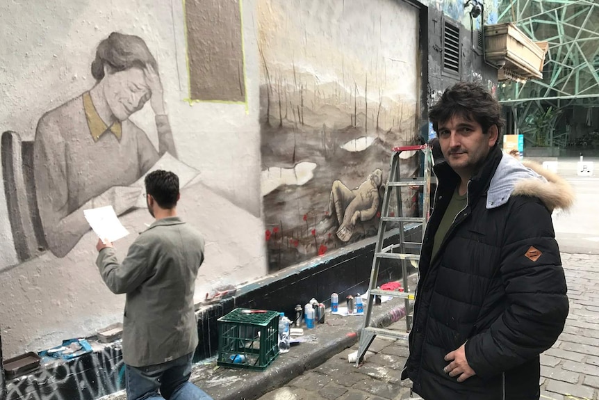 Artist Adrian Doyle in Hosier Lane in Melbourne in front of his mural.