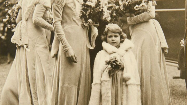A child in a fur coat with bridesmaids