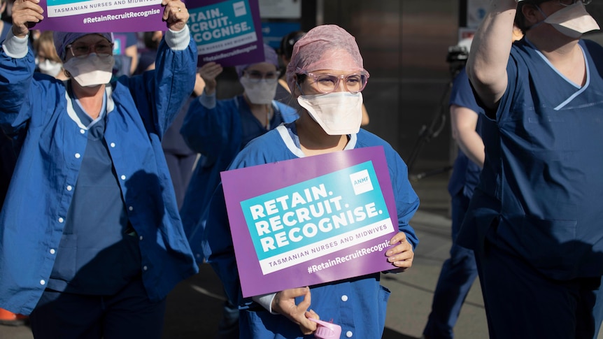 Nurses protest in Hobart, holding signs that say "retain, recruit, reorganise".