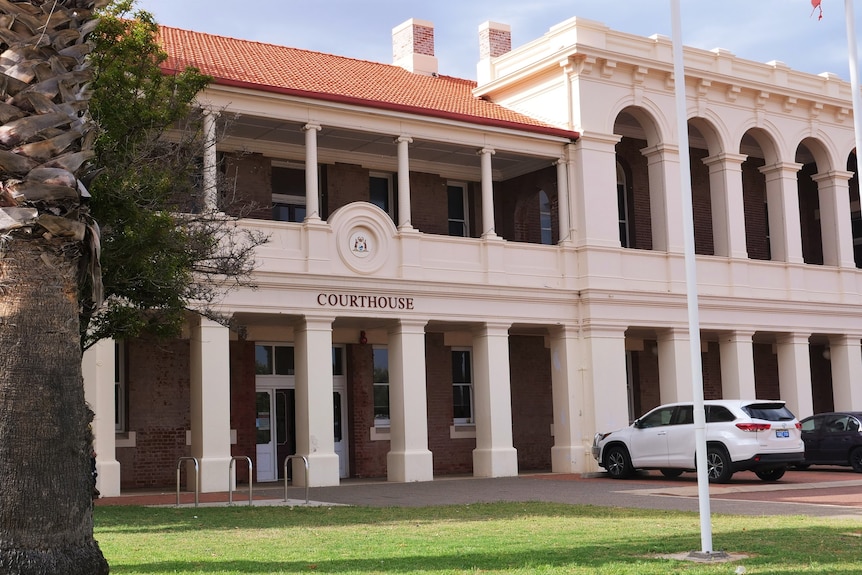 Exterior of Geraldton court house, flag poles with grass