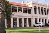 Exterior of Geraldton court house, flag poles with grass