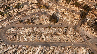 An aerial image of streets surrounded by burned debris