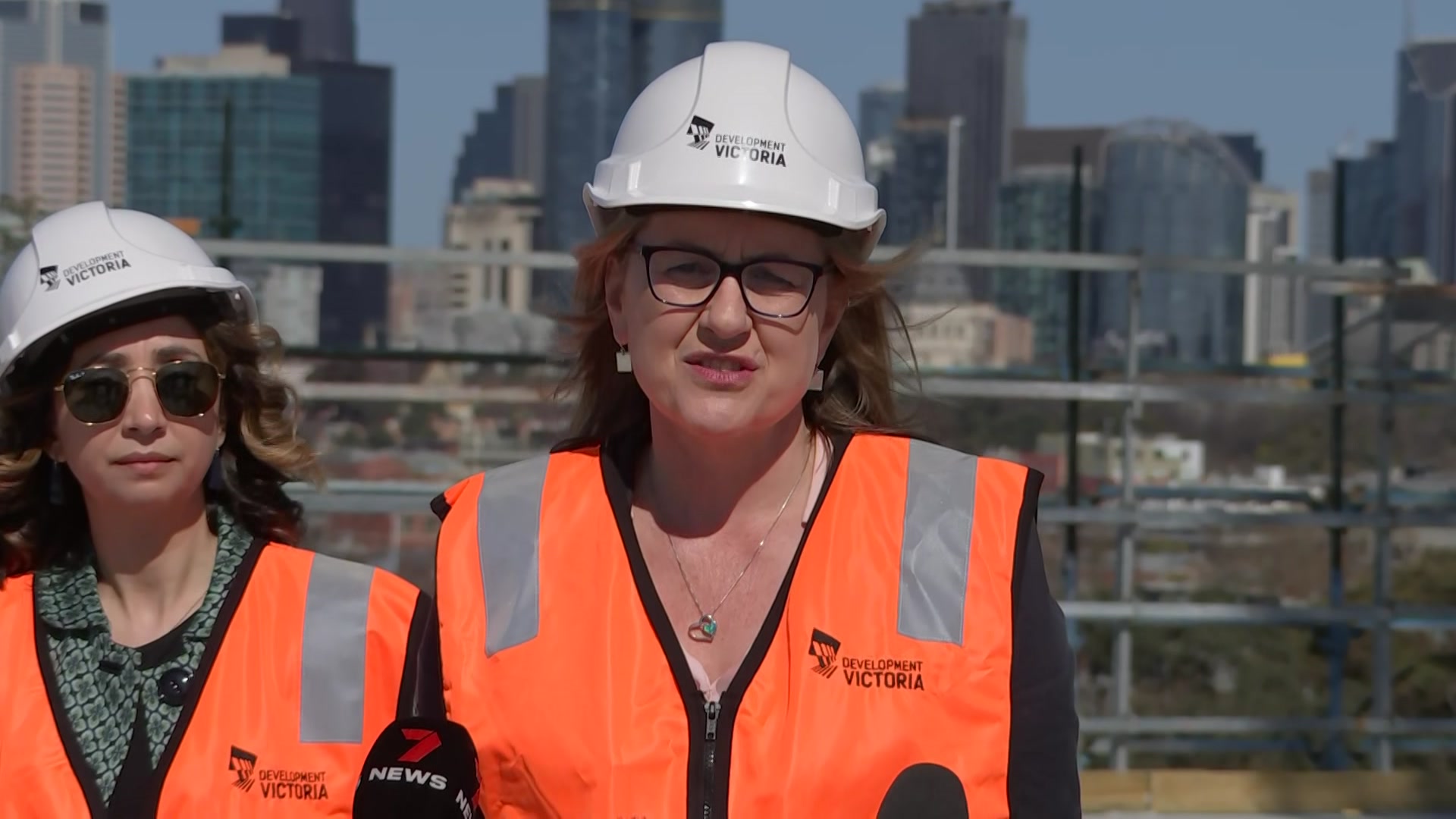 Dois homens com coletes fluorescentes e capacetes.