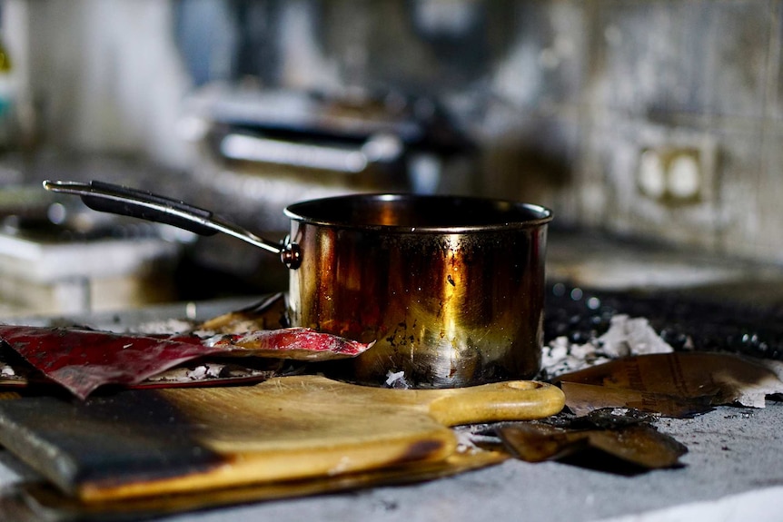 A burnt pot on a stovetop after a house fire.