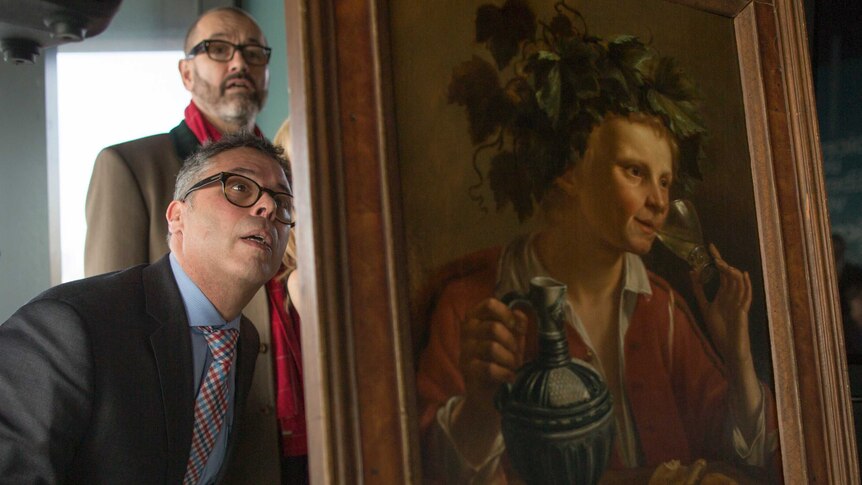 Dr Clarence Epstein inspects 'Young Man As Bacchus' painting