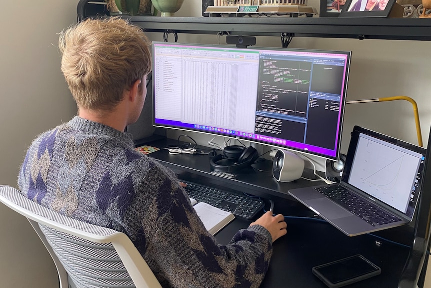 Image of a young professional sitting in front of a computer.