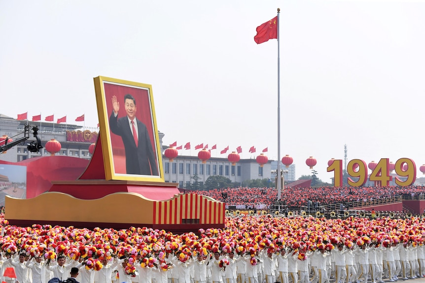 A float with a giant portrait of China's President Xi Jinping passes by Tiananmen Square.