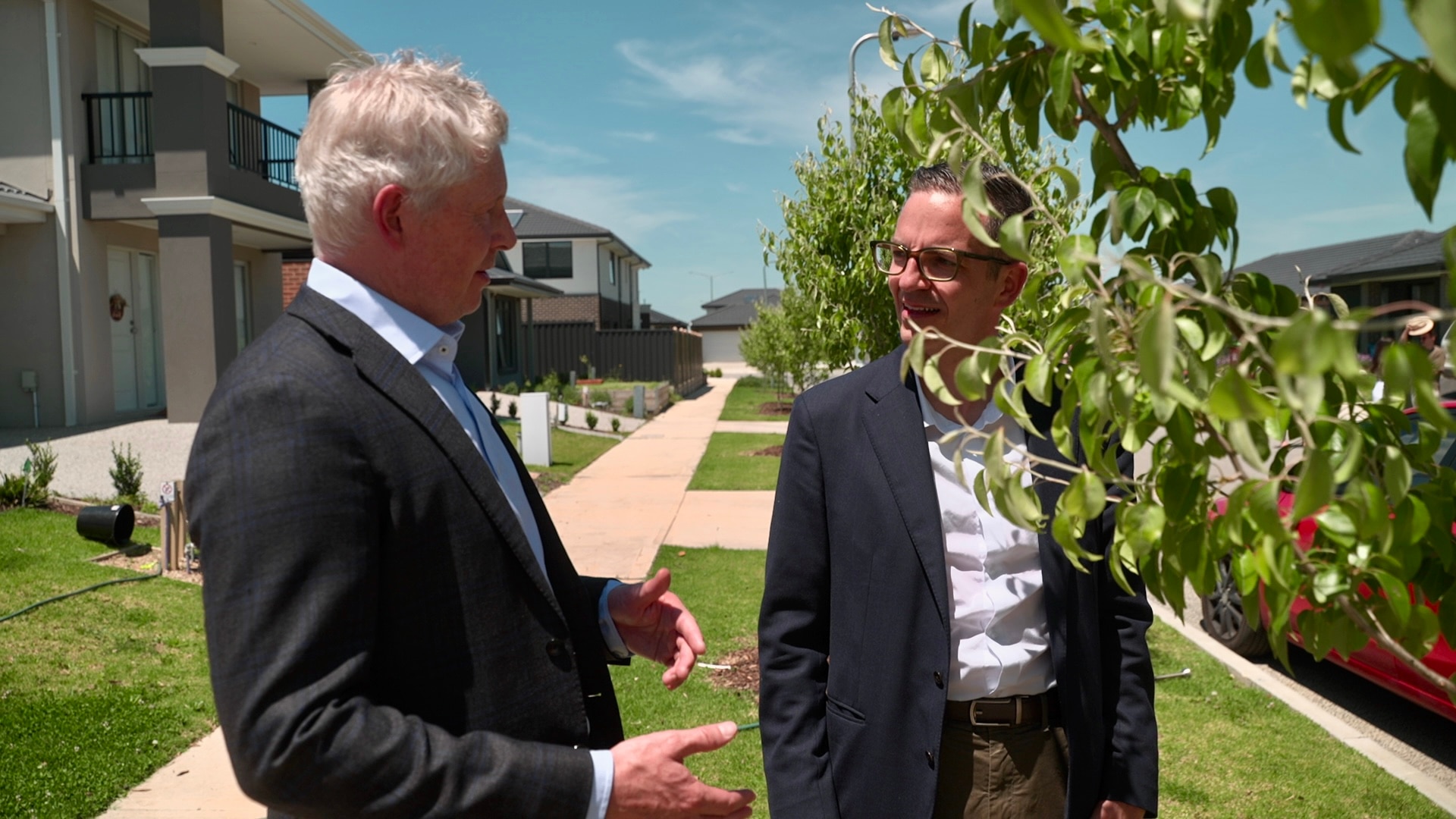 Dois homens conversando em uma rua suburbana