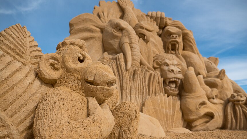 A monkey, elephant, eagle, lion, ape, rhino and python made from sand.