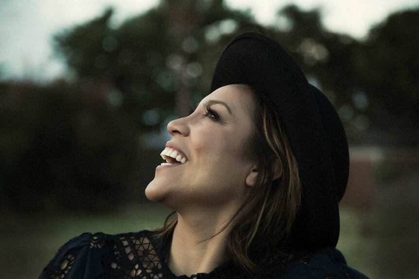 Singer Kate Ceberano smiles looking up at the sky
