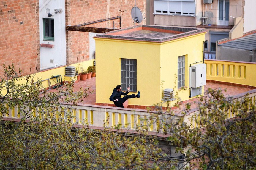 Neighbour practises karate across the plaza seen from rooftop home of Andrew Burden and Ali Cameron in Barcelona, Spain.