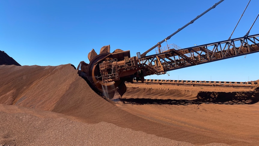 A reclaimer at Fortescue's Port Hedland facilities picks up and blends iron ore from a large heap.