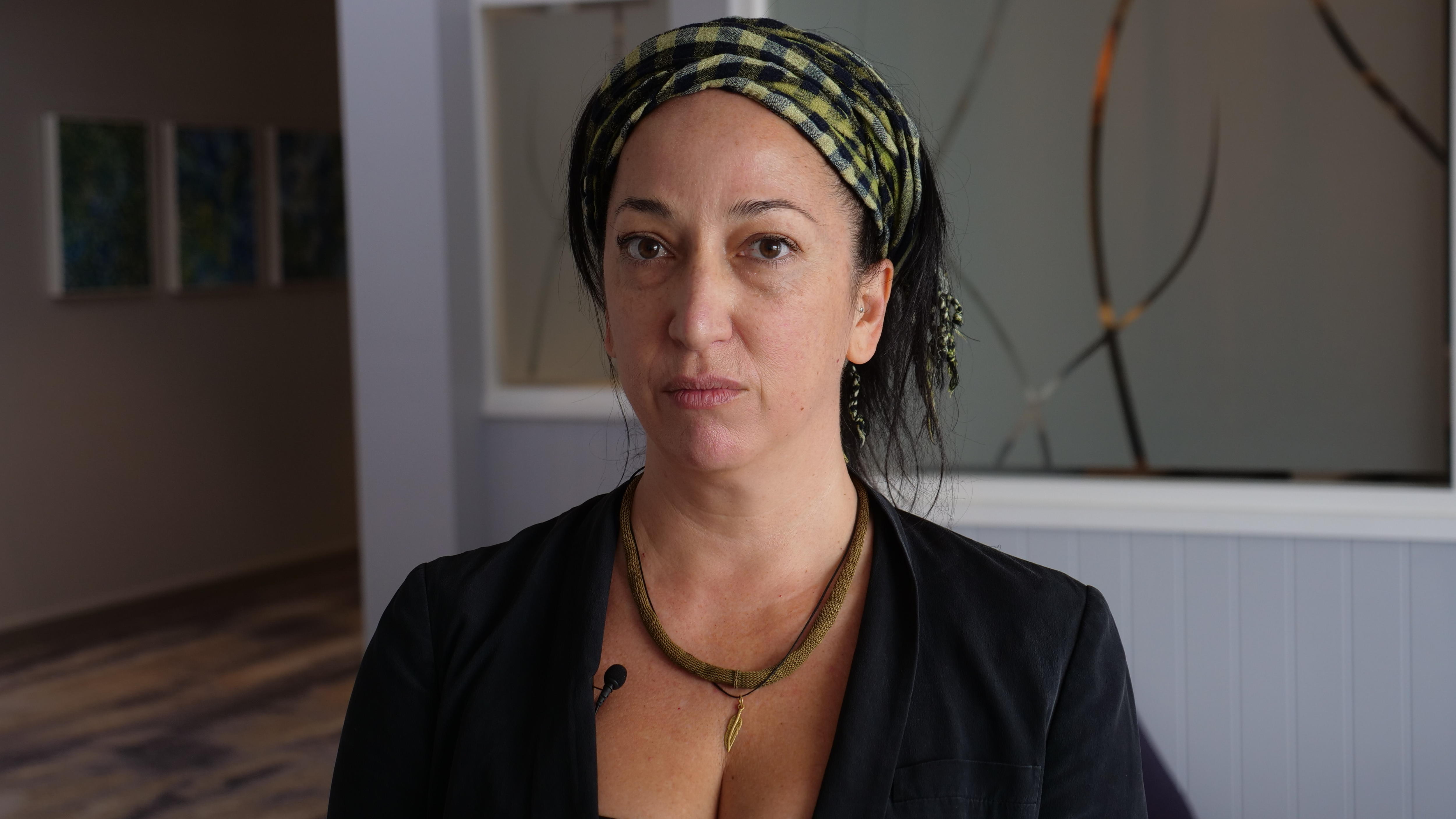 Una mujer mira a la cámara.