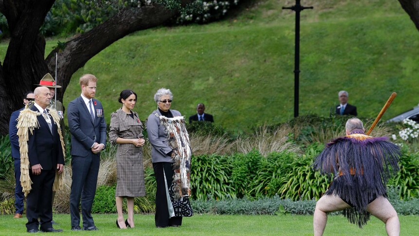 Meghan and Prince Harry stand as a Maori warrior makes an official welcome