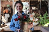 Organic flower grower Danielle White holding up a bouquet of flowers at her property.