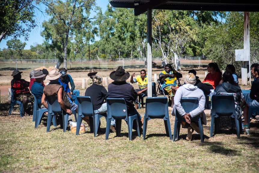 A group of people sit on chairs in a circle in Mataranka.