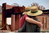 A couple look over their burnt out home following the bushfires. 