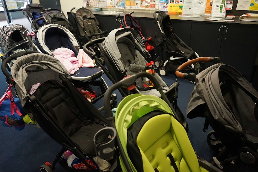 About eleven empty prams parked together.