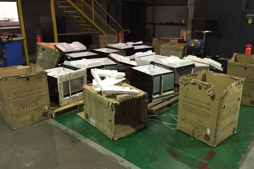Photo of a shipment of fridges, which packaging broken open.