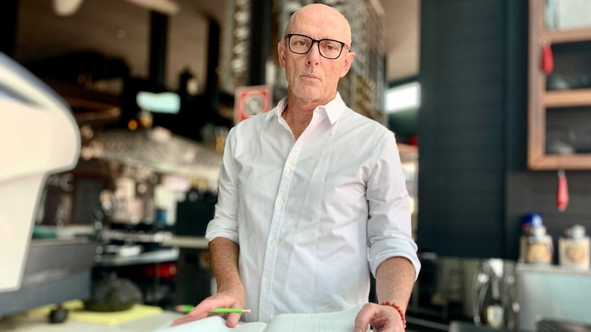 Glenn Boyland looks sombre as he leafs through a ledger book.