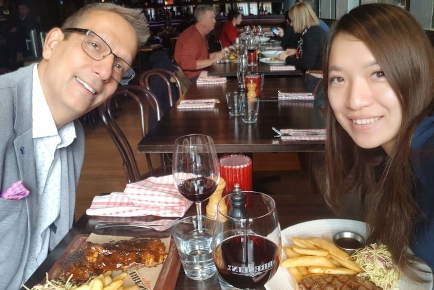 Man and woman sit at a table in a resturant.