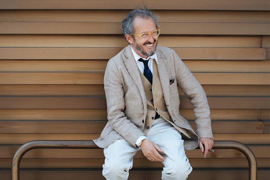 A London man wears a checked suit, vest and tie in brown hues.