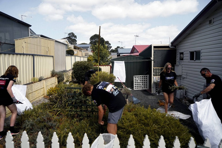 Kids helping in garden with white picket fence 