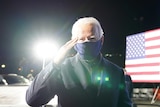 Joe Biden in a face mask saluting