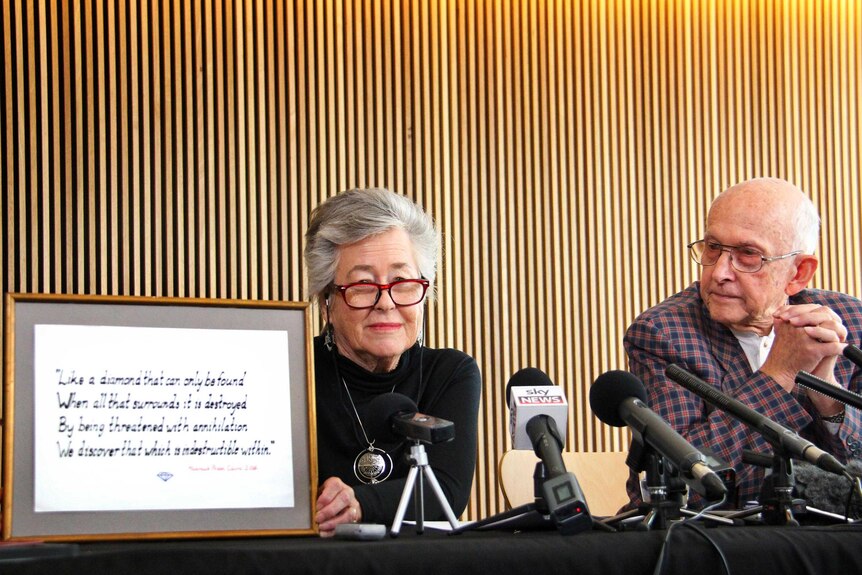 Lois holds a message written for her and husband, Juris (right), at a press conference in Brisbane today.
