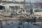 Burned cars are seen at the site of a Russian military strike.