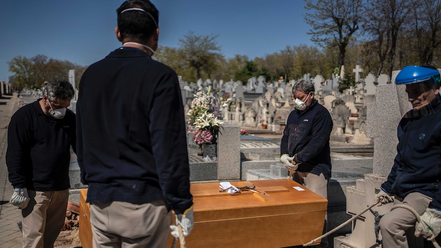 People bury an elderly COVID-19 victim in Spain.